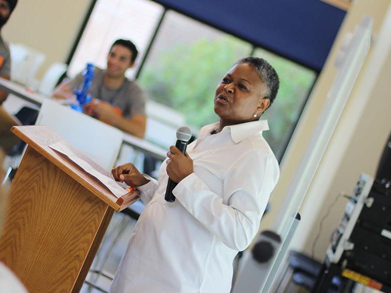 chancellor richardson speaking to an audience of faculty and staff with a microphone